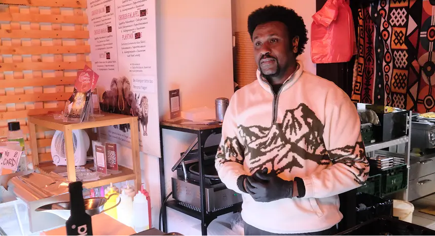 Mann in Restaurantküche präsentiert zubereitetes Gericht